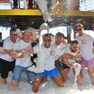 Teammitglieder feiern im Schaum auf dem Schiff