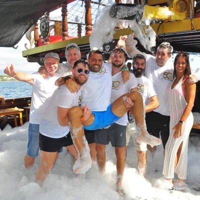 Gruppe hebt Kollegen beim Feiern auf dem Schiff hoch